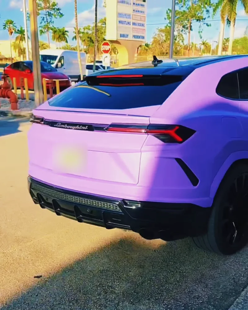The purple Urus from the back, in the sun