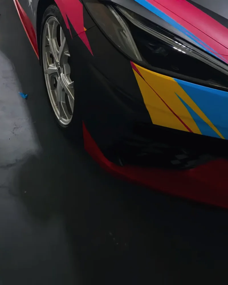 Corvette front corner: pink, blue and yellow bolts, a red lip and the headlight