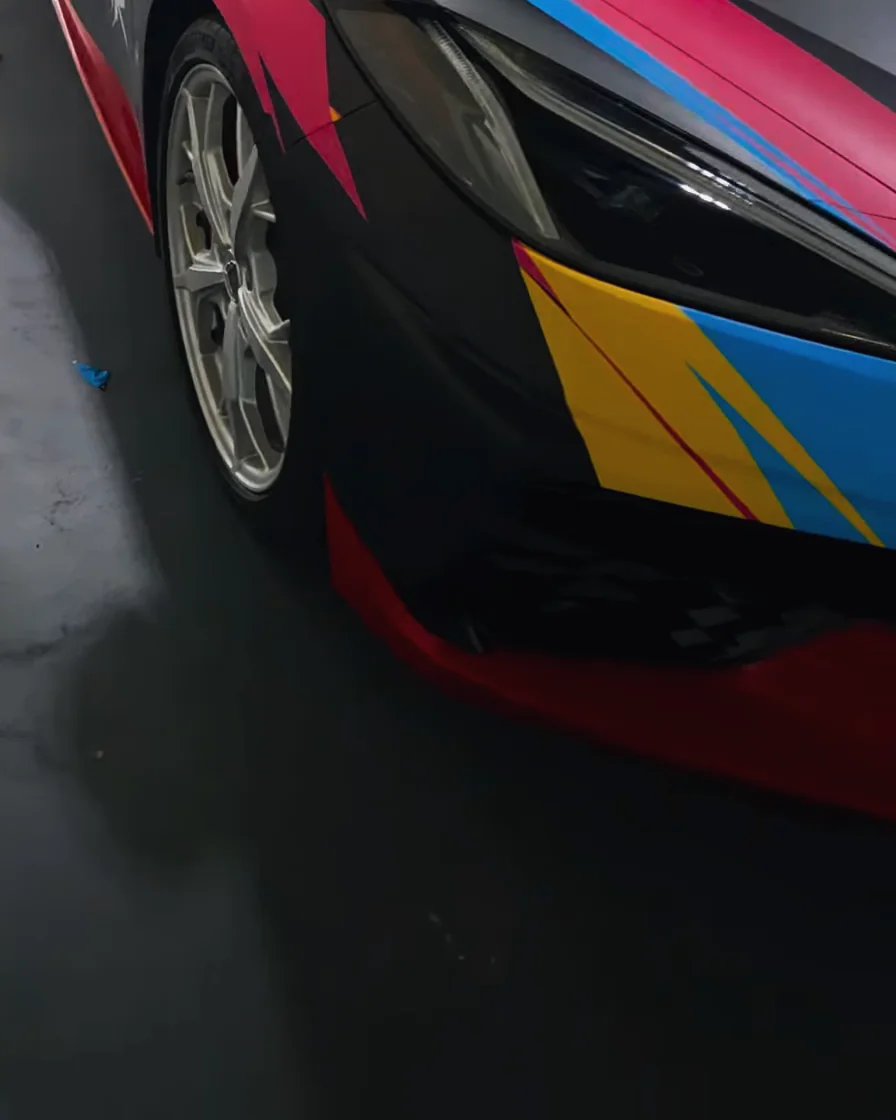 Corvette front corner: pink, blue and yellow bolts, a red lip and the headlight