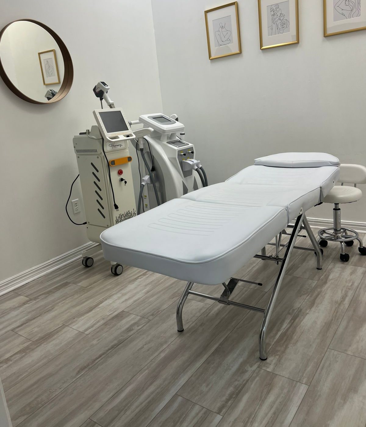 The white laser room, with the diode laser beside the treatment bed and a round mirror on the wall