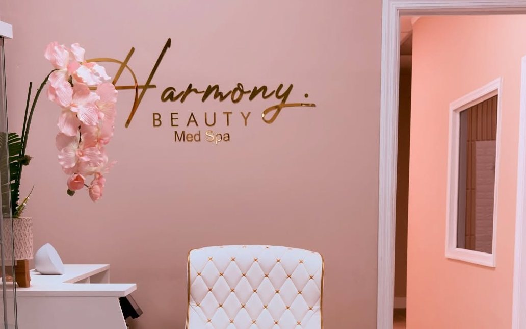 The gold Harmony sign on the rose wall of Suite 12