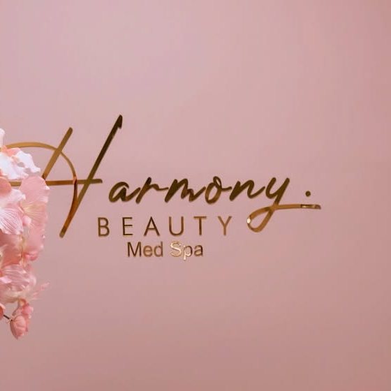 The brushed-gold Harmony sign, with a pink orchid beside it