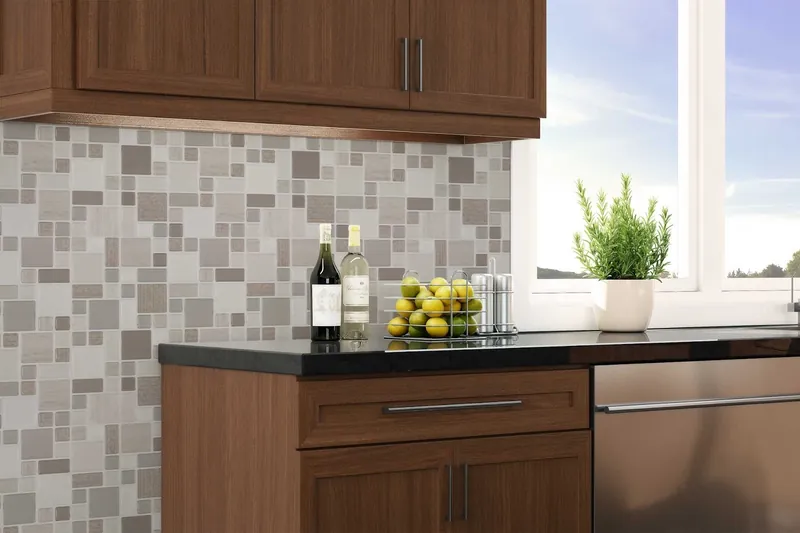 A kitchen with a grey and white mixed-square mosaic backsplash