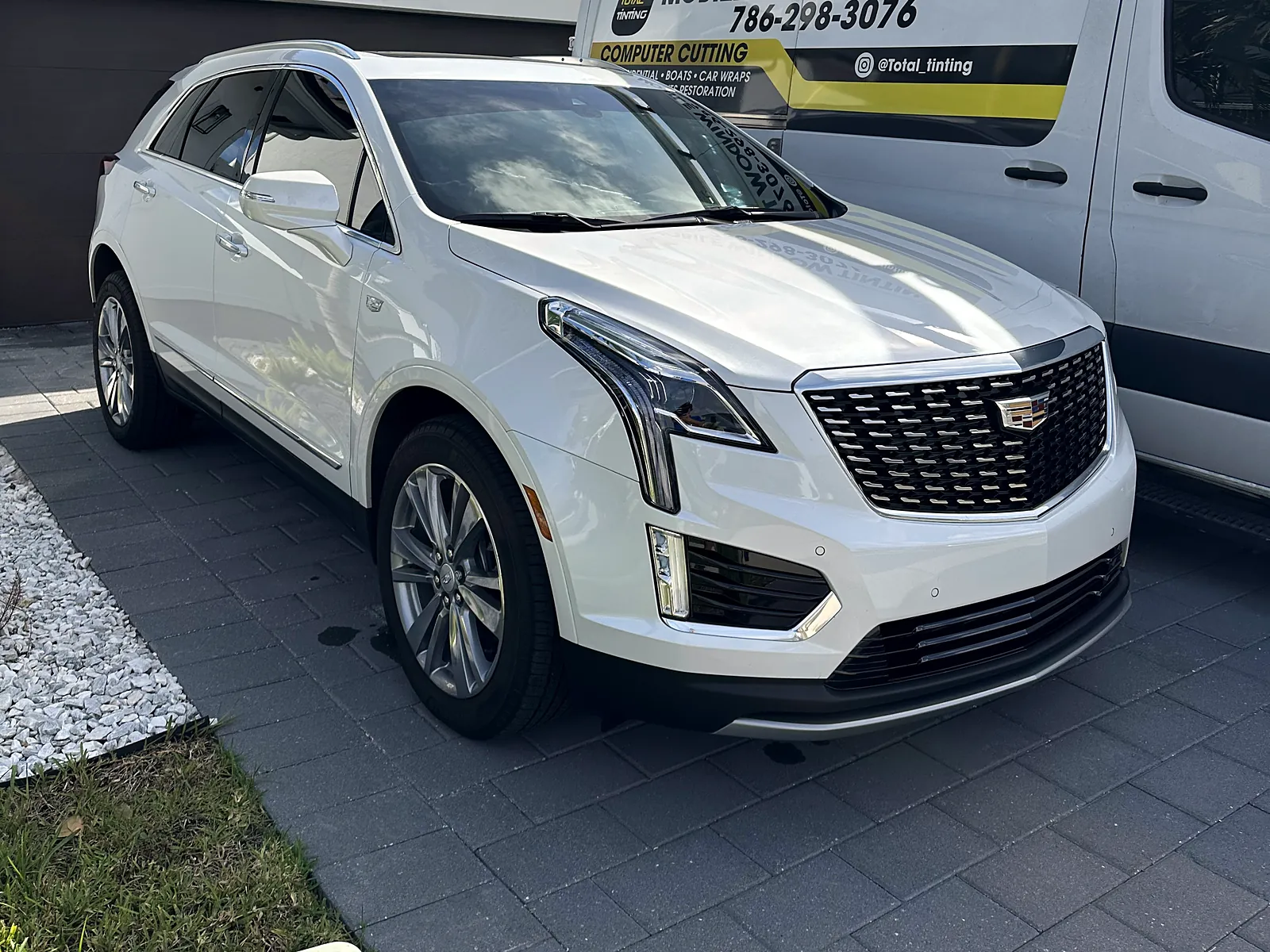 Cadillac XT5 with fresh tint beside the lettered Total Tinting mobile van